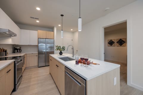 Kitchen stocked with all culinary essentials and fully equipped with brand-new stainless-steel appliances. Features an island with bar seating.