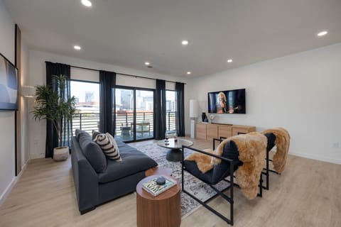Spacious living room with wilderness-inspired decor featuring smart TV, comfortable seating, and private patio.