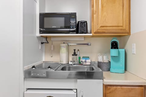 Kitchenette with Keurig, microwave, mini fridge, sink, two electric stove top burners