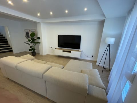Living room with large sofa and 70 inch TV with PrimeVideo and Airplay TV