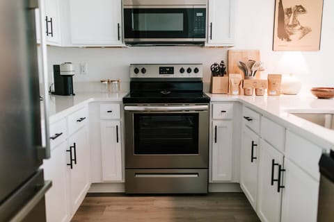 Welcome to the heart of culinary inspiration!  Step into our modern kitchen, adorned with sleek stainless steel appliances that gleam with possibility. This snapshot captures the essence of gourmet convenience, where every tool and ingredient awa