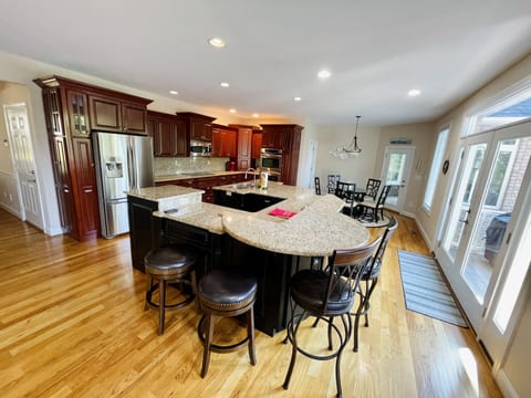 fully-stocked kitchen with gas grill on porch.