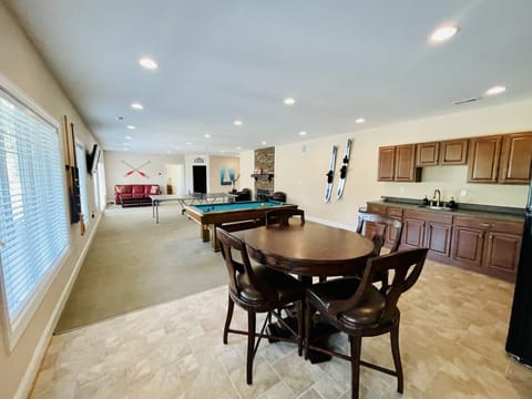 lower level game room with ping pong, poker, pool, TV, and kitchenette.