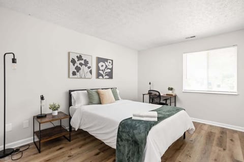 We've created a cozy space with a bed adorned in soft pillows and fresh linens. Bedside tables with lamps and a few frames on the wall enhance the ambiance, ensuring a restful sleep in our carefully designed bedroom.