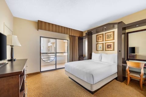 Unwind in crisp white bedding with balcony light streaming in.