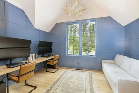 A versatile game and office room with an ensuite full bathroom, Queen pull-out couch, and multiple monitors—perfect for work, play, and hosting guests.