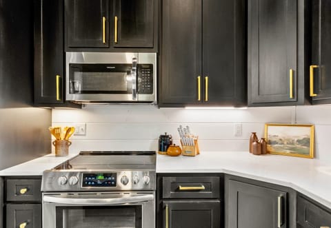 Enjoy the details that make a kitchen special, from the sleek cabinetry with chic gold handles to the modern appliances ready to assist with your culinary creations.