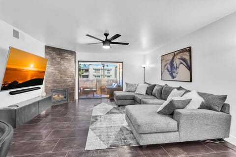 Living room has 65" Smart TV with Cable, sectional sofa & fireplace