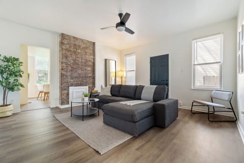 Large bright spacious living area with couch, pillow and throw 