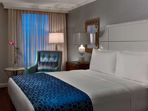 Relax into a plush bed framed by soft evening glow.
