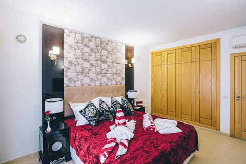 Unwind under warm sconces beside a statement upholstered headboard.