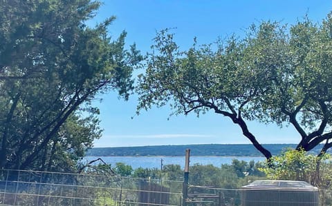 Peaceful lake view from the apartment patio with 2 Adirondack chairs and a small bistro table 
