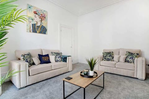 Unwind in the bright living room, complete with a Smart TV, ample seating, and a striking accent chair. A comfortable space designed for relaxing after a busy day.