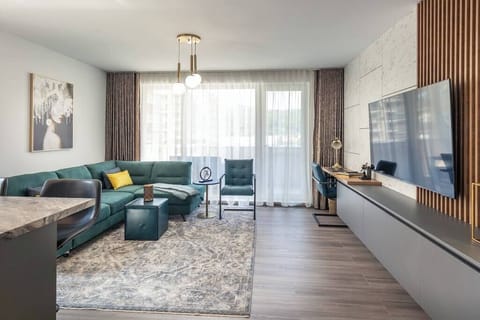 Spacious open living room with HD Smart TV, dedicated workspace and balcony. The property has a dedicated parking and access to playground