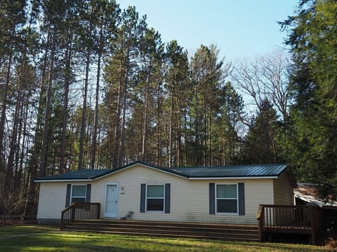 A nice overview of the front of the house, highlighting the front porch and the huge pine, cedar, and hemlock trees in the backyard.