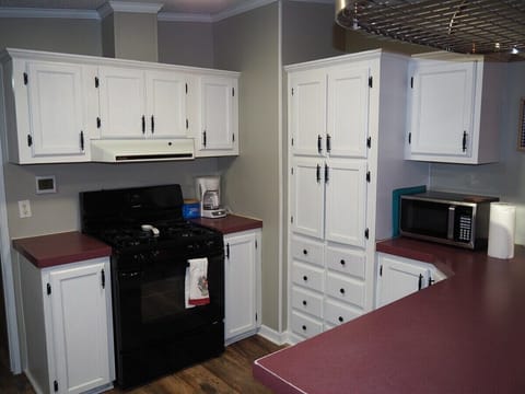An overview of the kitchen, which includes a gas range (stovetop and oven), dishwasher, refrigerator, sink, microwave, coffee maker, toaster, and lots of counter and cabinet space.