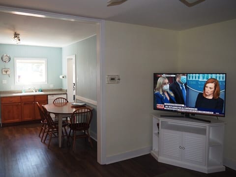 LIVING ROOM: The apartment has a cozy living room with a sofa, chair, ceiling fan, and live streaming television.
