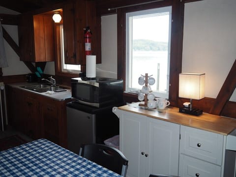 KITCHEN:  The cottage has a small kitchen with all appliances except for a dishwasher.  It does include a separate beverage cooler as well as a good supply of cooking and dining utensils.