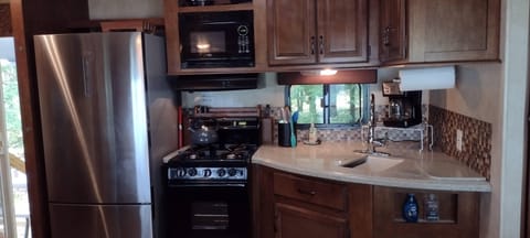 KITCHEN:  The home has a cute little kitchen with a refrigerator, sink, counter, stove, oven, and microwave.  There is also a collection of cooking and dining utensils provided.