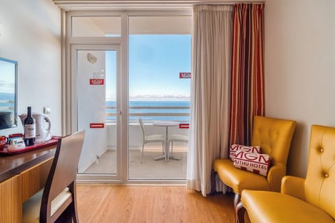 Relax in cozy lounge seating beside the sunlit balcony doors.