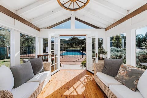 A comfortably furnished sunroom opens up to the pool area through sliding glass doors.