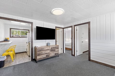 Living room with entrance to kitchen, both bedrooms and bathroom.