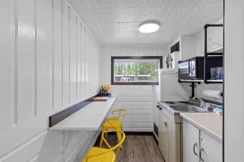 Kitchen with countertop seating, mini fridge, microwave, two electric stove top burners, cooking and dinnerware