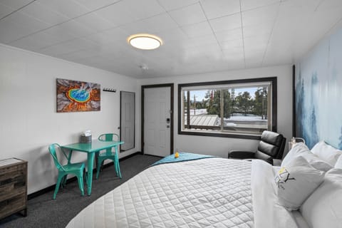 Main room with king size bed, table for two and full length mirror