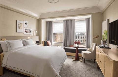 Unwind in crisp linens with sweeping city views beyond.