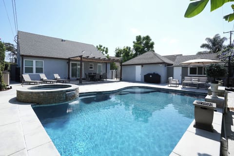 Outdoor dining table, living set and chaise loungers along side beautiful pool.
