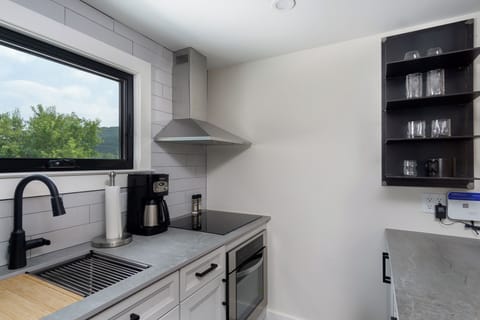 Open-concept kitchen with stainless steel appliances and breakfast bar seating for 2. Please note: The standard drip-style coffeemaker has been replaced with a Keurig.