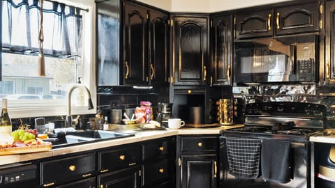 Bold backsplash, black cabinets, and golden details pop