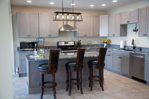 Kitchen- Fully stocked kitchen with modern appliances and breakfast bar seating.
