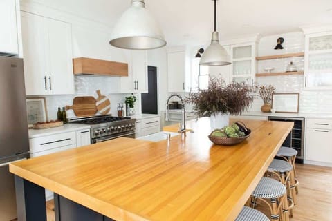 Modern warmth meets gourmet vibes.

Enjoy a sunlit kitchen with premium appliances, open shelving, and a spacious island crafted from custom maple bowling alley.