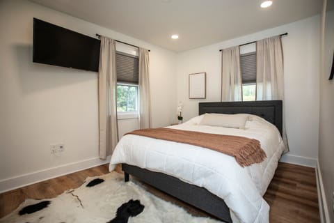 Primary bedroom on the first level is equipped with TV, closet and plush linens