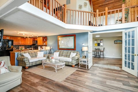 Living room with a glimpse of the gaming area and 2nd story balcony.