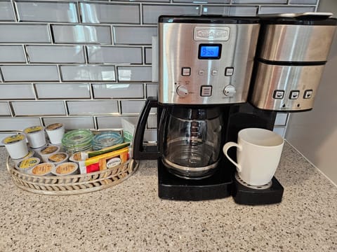Coffee station includes a selection of K cups, teas, sugar, and creamer