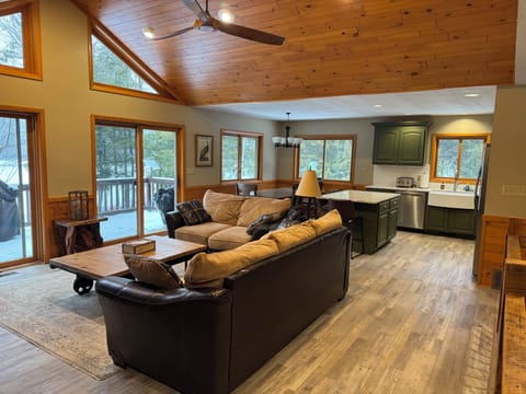 Open living, dining, kitchen opens to lakeside deck with gas grill.