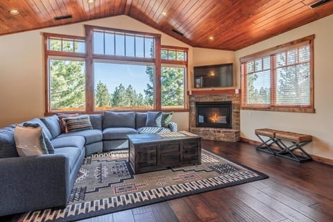 Large open plan living room with ample seating and views of the golf course, gas fireplace, smart tv and an abundance of light.  The living room opens up onto one of the two top decks.