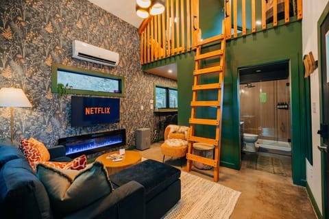 Curl up together in this cozy cabin lounge with Netflix, electric fireplace glow, and romantic loft charm.