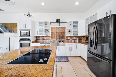 Stepping into this inviting kitchen, your eyes are immediately drawn to the sleek and spacious kitchen island.