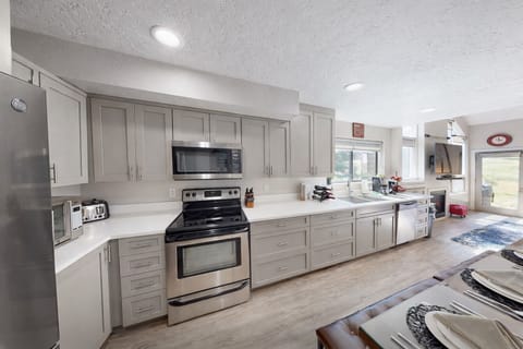 This fully equipped gourmet kitchen offers a clean, contemporary design with ample workspace. Whether preparing a quick snack or a full feast, enjoy top-tier functionality and style.