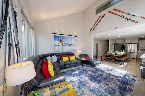 Relax in your spacious living area with plush sectional seating, ski-themed decor, and an open kitchen perfect for après-ski gatherings.