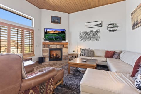 Bear Hollow Village 5595: Cozy sofa set by fireplace, framed by a picturesque window view.