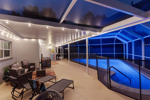 Beautiful blue lit pool w/ lighted, caged pool area