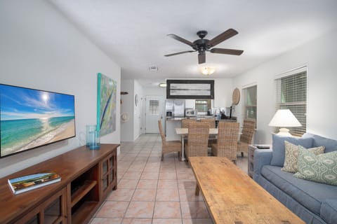 Relax in your spacious living area with comfortable seating, large TV, and cooling ceiling fan while enjoying ocean views.
