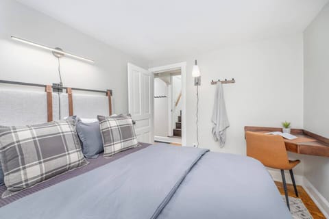 Main floor bedroom with a queen size bed and a dedicated work station.