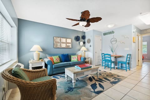 Cozy living area with coastal decor and a dining nook for four.