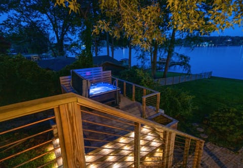 Evening view of the hot tub area, softly lit and overlooking the lake.