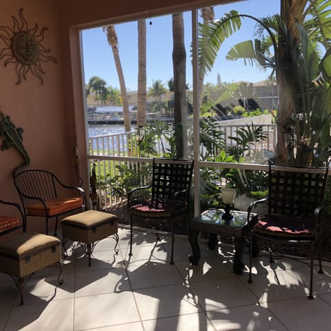 view from full opening slider in living room out to patio, pool deck and canal